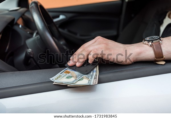 Car\
key and dollar in hand inside auto. finance\
concept