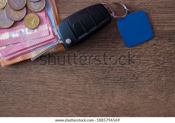 Car key and euro money on wooden background. Car\
loan concept, saving money for car concept, trade car for cash\
concept, finance concept