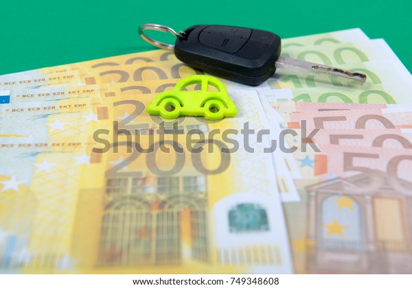 car key and euro\
money on a green carpet