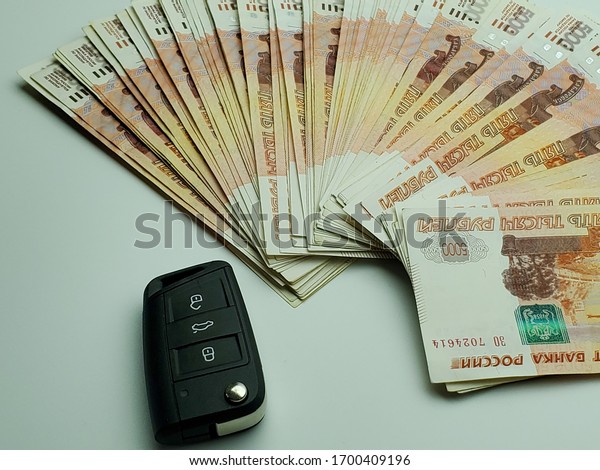 car key\
and a fan of Russian banknotes, Russian rubles. Concept of buying,\
renting, leasing, carsharing, car\
loan.