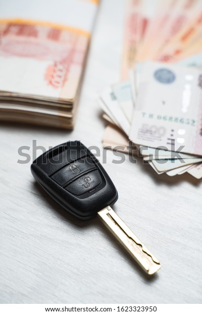 car key lies on a table with rubles banknotes,\
Russian rubles and a car\
key