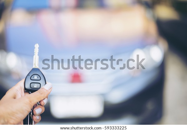 Car key lock. woman Hand presses on the\
remote control car alarm systems.Cross processing.Auto insurance\
business.Car security lock  system\
concept.
