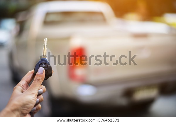 Car key lock. woman Hand presses on the\
remote control car alarm systems.Cross processing.Auto insurance\
business.Car security lock  system\
concept.