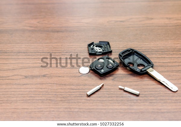 Car key maintenance concept change battery  by\
screw driver on the wood table\
