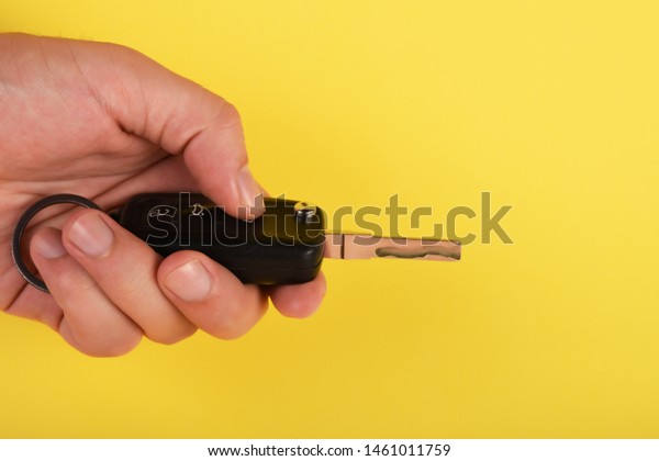 Car key, A male\
finger pushing car key\
button