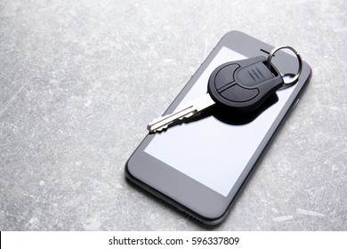 Car Key And Mobile Phone On Grey Table