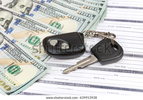 Car key and money on the\
documents.