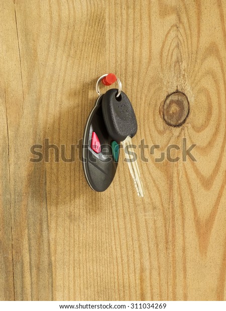 Car key\
with remote control hanging on wooden\
board