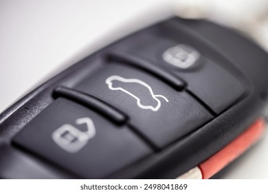 Car key remote featuring lock and unlock buttons, illustrating the convenience and modern technology within automotive security. Automotive industry, security features, remote open, close and trunk 