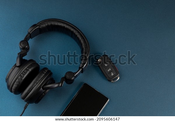 car keys and entertainment accessories,\
headphones and cell phone, with space for\
text