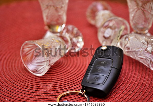 car keys lie next to alcohol glasses. Driving a\
car after drinking alcohol.