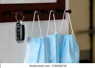 Car Keys And A Medical Face Mask Hang On A Key Hanger Rack.