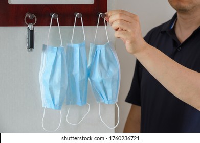 Car Keys And A Medical Face Mask Hang On A Key Hanger Rack.