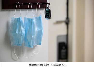 Car Keys And A Medical Face Mask Hang On A Key Hanger Rack.