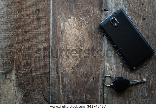 car keys and mobile on\
a wooden floor