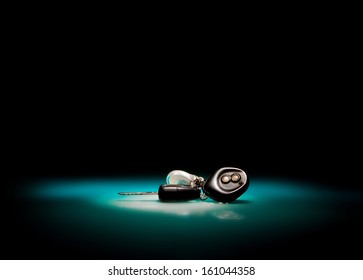 Car keys on blue, reflective table and black background 
