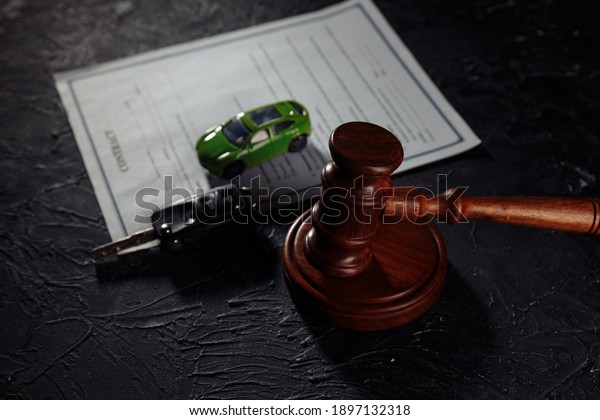 Car with keys on\
contract and wooden judge gavel. Concept of selling a car by\
auction or accident\
sentence