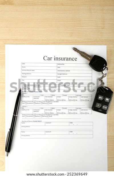 Car keys on\
insurance documents, close\
up