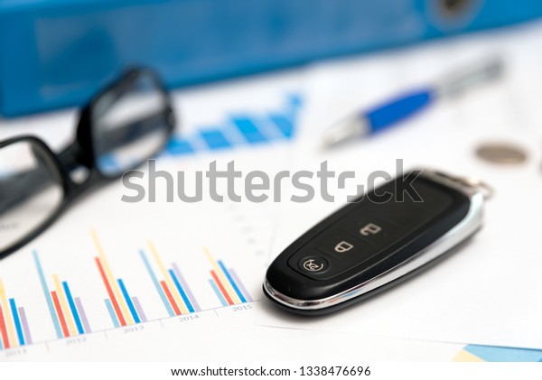 Car keys, remote control, binder with car\
loan label. Car rental or car loan\
concept