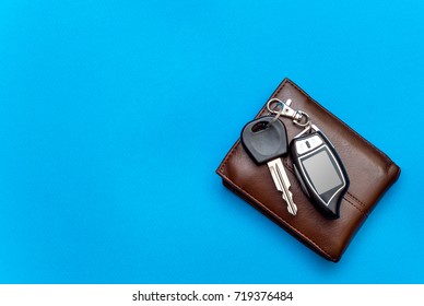 Car keys with wallet on blue background. Top view. - Powered by Shutterstock