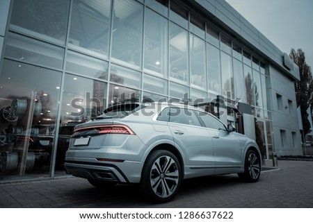 Car leaving. Low angle of nice silver comfortable family hatchback car leaving the car salon