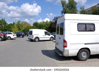 A Car Leaving The Parking Lot In The Background Of Parked Cars