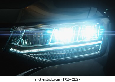Car LED headlights in night. New modern car headlamp, close up