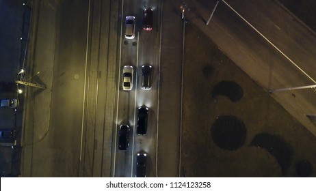 The Car Light Trails In The City Intersection, Traffic. Video. Top Down Aerial Drone View Of A Road At Night With Cars Driving, Headlights Reflecting. Aerial View Of Highway Empty Road City Street In