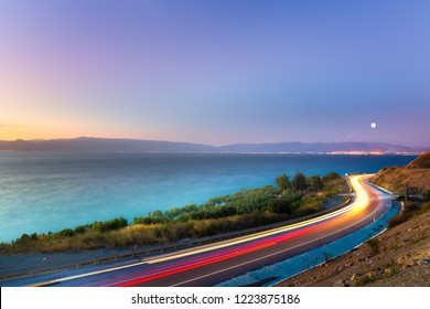 Car lights and coastal path at sea shore. Car lights on the road near the coast. Coastal highway. Mudanya, Bursa, Turkey 
 - Powered by Shutterstock