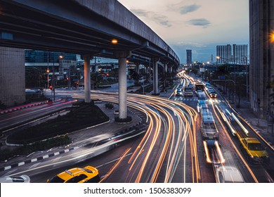 Car Lights At Evening On The Road Going To The City. Aerial View Of The Speed Traffic Trails On Motorway Highway In Yannawa, Rama 3, Bangkok, Thailand. Long Exposure Abstract.