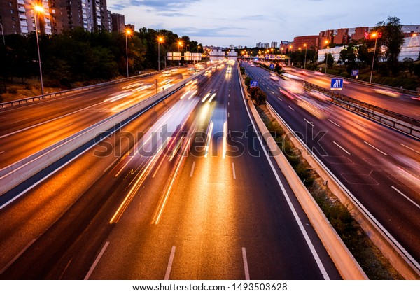 Car lights\
running at full speed through a network of roads within the city,\
long exposure to capture the\
movement.