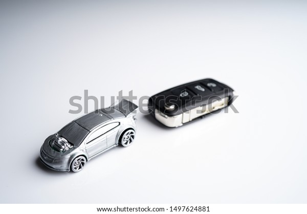 Car\
loan, Insurance, buy and sell and Auto Finance conceptual image\
with Car Key remote, die cast car and dollar bills\
