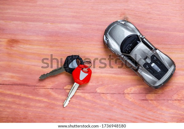 Car Loans, Credit Concepts. Scale Car Along\
With bunch of Keys Against Vintage Wooden Background. Horizontal\
Image Orientation