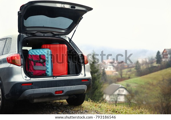 Car with luggage in\
countryside
