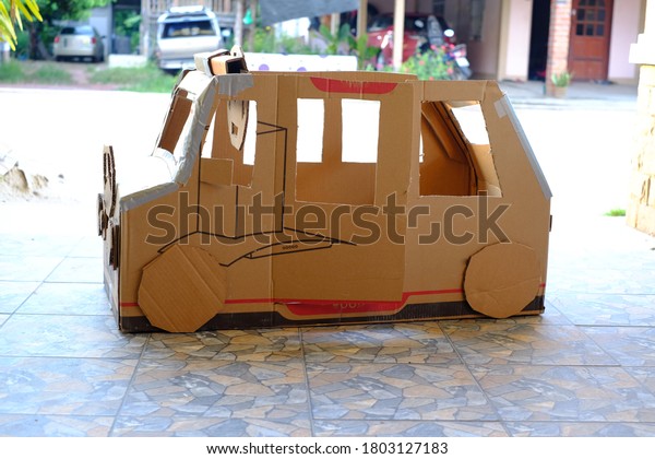A car made of brown used cardboard Soft
background, natural light.