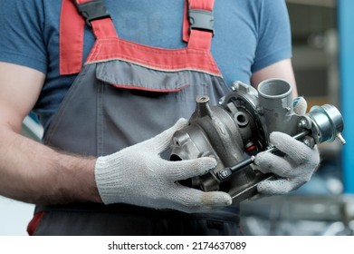 Car maintenance. An auto mechanic holds a new turbocharger in his hands. Inspection and control of the spare part for the engine for compliance and integrity. - Shutterstock ID 2174637089