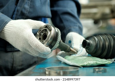 Car maintenance and repair in the car center. A joint of equal angular velocities in the hands of an auto mechanic. Inspection and control of the conformity and integrity of the spare part. - Shutterstock ID 2148997397