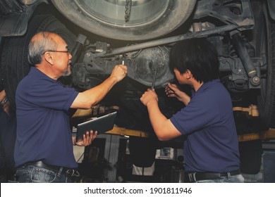 Car Maintenance : Senior Technicians Check The Work Of The Mechanic During Maintenance Of The Suspension And Differential Nut Tightness Of The Utility Vehicle To Ensure Customer Safety.