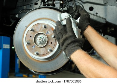 Car maintenance in the service center. Pulling up the stabilizer bar attachment. - Shutterstock ID 1787301086