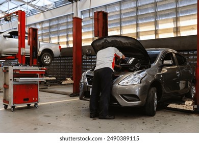 Car Maintenance Technician Working on Engine - Powered by Shutterstock