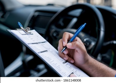 A Car Maintenance Worker Is Checking A List Of The Car Interior For A Workshop Customer.