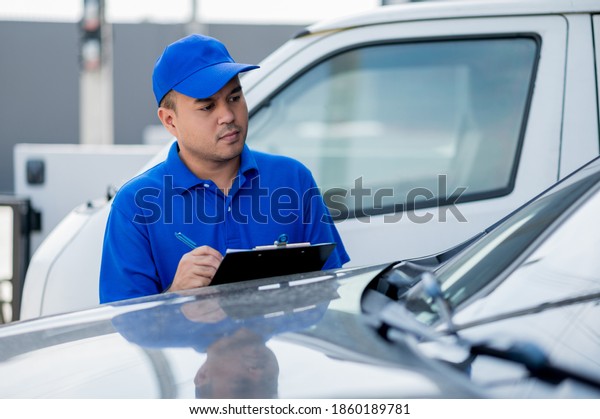 A car maintenance
worker is checking a list of items for car maintenance for a
workshop customer.