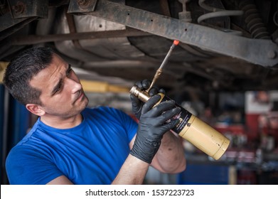 Car master mechanic repairer heating the screws with butane gas blow mini welding torch flamethrower burner in vehicle repair service - Powered by Shutterstock