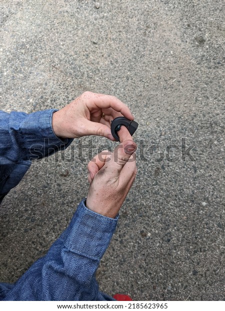 A car mechanic adding grease to a new bearing for a sway\
bar 
