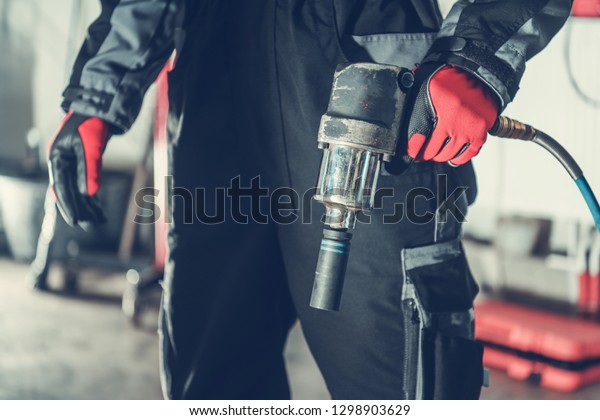 Car Mechanic with Air Impact Wrench Pneumatic\
Gun. Automotive Industry.