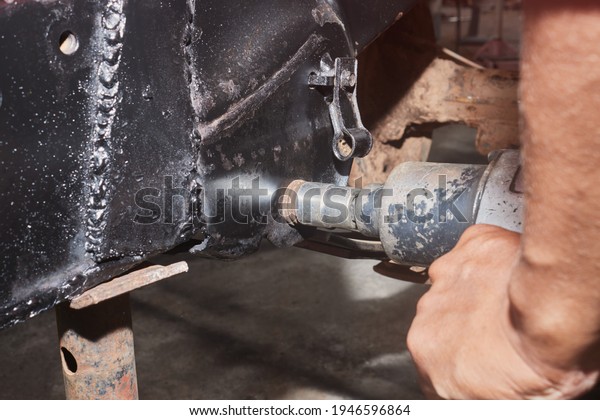 Car Mechanic or Auto Mechanic Tighten Nut of Car\
Leaf Spring by Wind Block