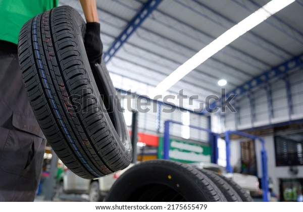 Car mechanic\
change tire In the process of bringing 4 new tires to a tire shop\
to replace motorcycle wheels at a service center or auto repair\
shop for the automotive\
industry