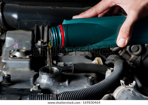 Car mechanic changing engine\
oil