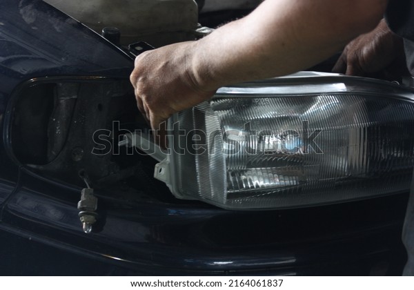Car Mechanic changing car\
lamps