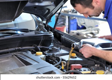 Car Mechanic Changing Oil - Model And Oil Motion Blurred.